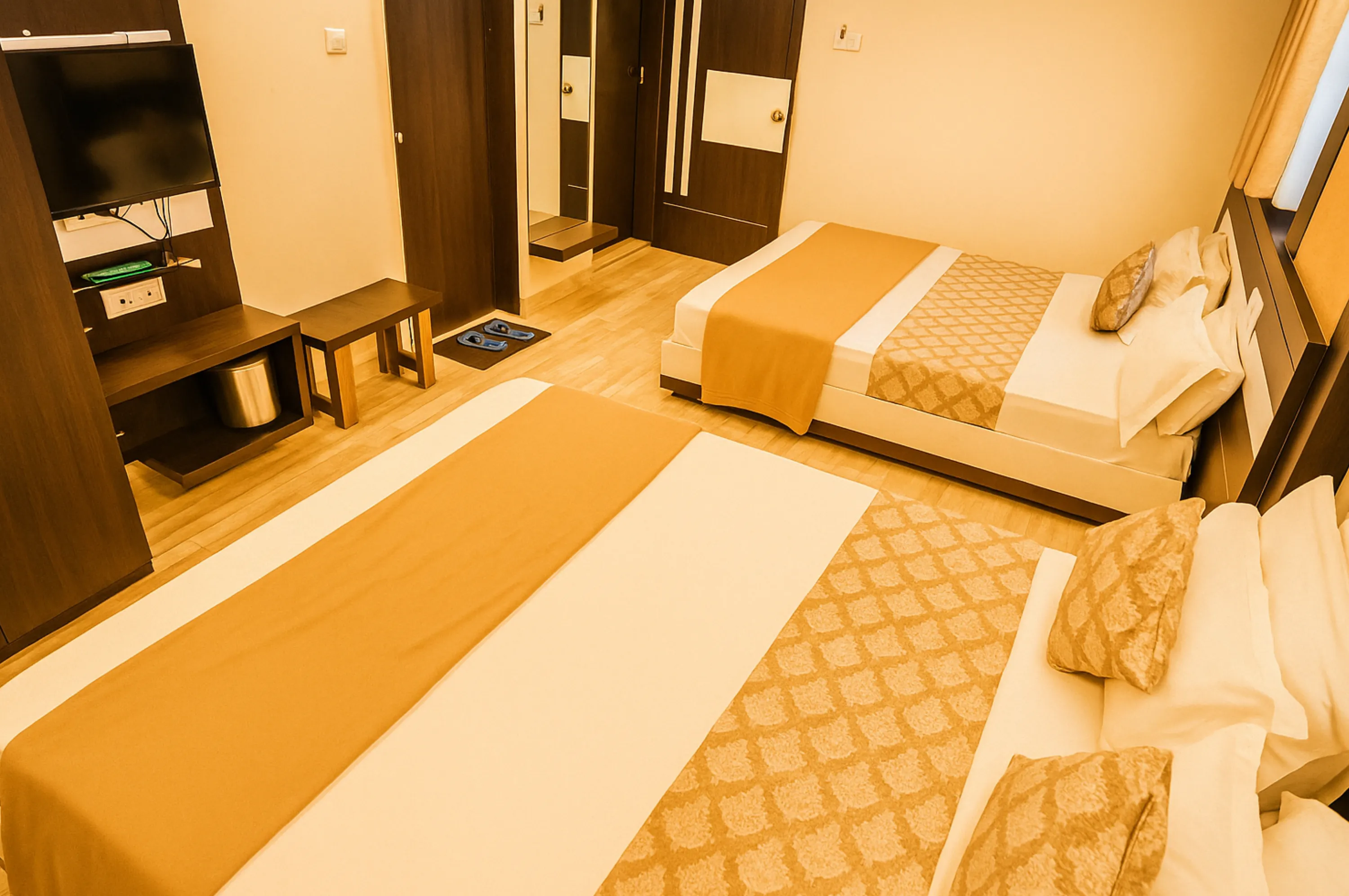 Deluxe four bed AC family room at Hotel Vrajbhoomi Somnath with modern interiors.